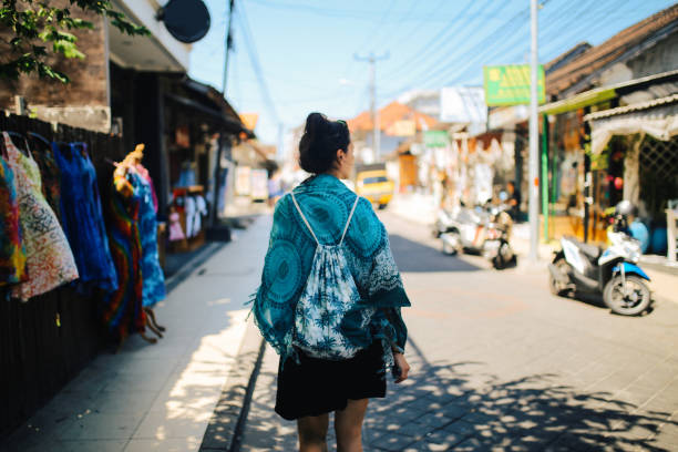 Young woman, solo tourist, walking the streets in Kuta, on the island of Bali, Indonesia.