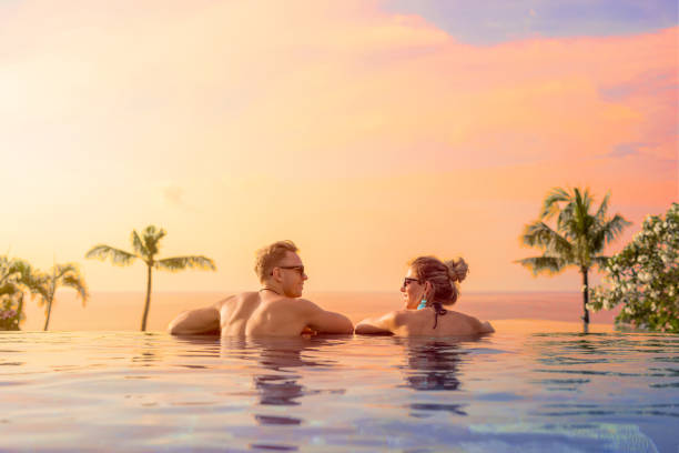 Happy couple enjoying honeymoon in luxury hotel pool in bali